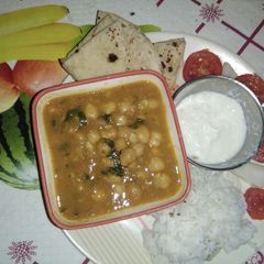 A picture of Punjabi choley with rice (in proper lunch thali).