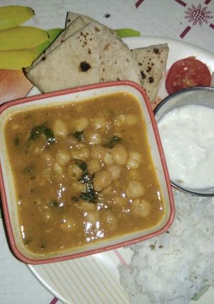 A picture of Punjabi choley with rice (in proper lunch thali).