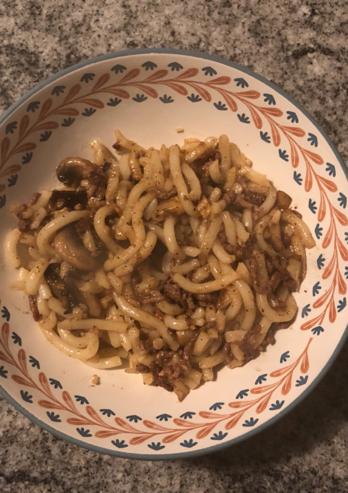A picture of Udon with ground beef and mushroom.