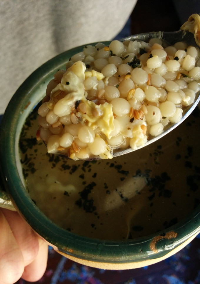 A picture of Basil egg drop couscous soup.