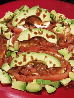 Una foto de Tomate, mozzarella y aguacate marinados con vinagreta de tomate