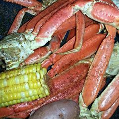 A picture of Crab legs w/ Corn & Potatoes.