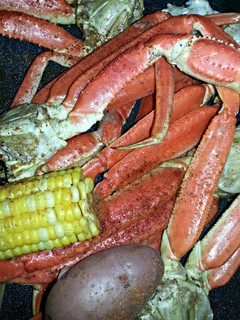 A picture of Crab legs w/ Corn & Potatoes.