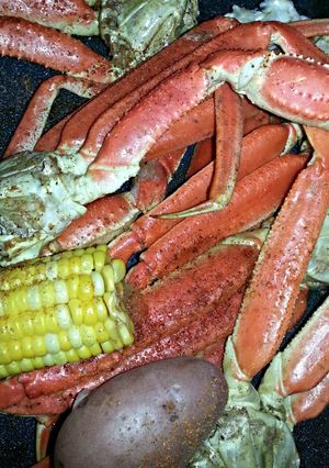 A picture of Crab legs w/ Corn & Potatoes.