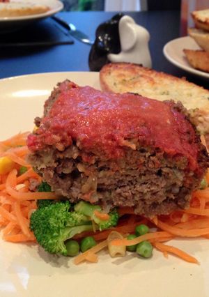 A picture of Meatloaf with tomato and red pepper sauce.