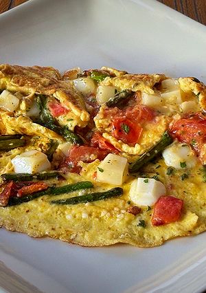 Una foto de Tortilla de espárragos, tomatitos y queso semicurado de cabra