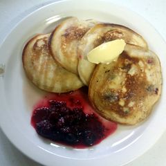 A picture of Fluffy pancakes with maple syrup butter and seasonal berries.