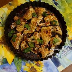 A picture of Baked cauliflower topped with parmesan cheese.