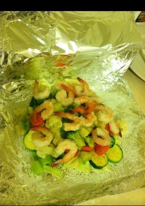 A picture of Foil wrapped veggies & shrimp.