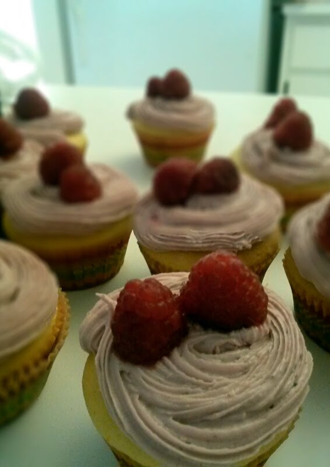 A picture of Lemon cupcakes with raspberry frosting.