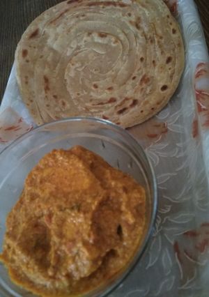A picture of Shahi paneer and lachcha paratha.