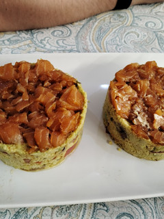 Una foto de Tartar de salmón y anchoas con base de cuscús y salsa de mayonesa y mostaza
