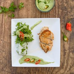A picture of Chicken breast served with coriander rice, rocket salad and avocado coriander sauce.