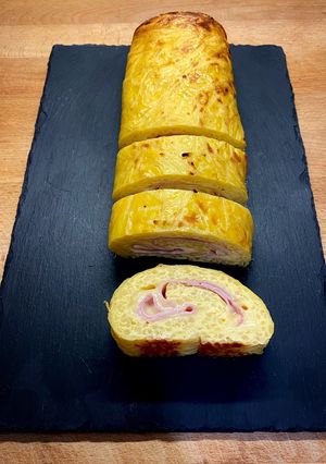 Una foto de Tortilla de patatas enrollada con jamón y queso