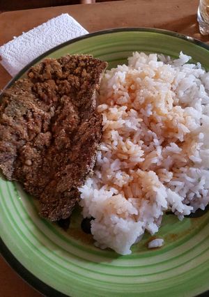 Una foto de Milanesa con arroz o puré
