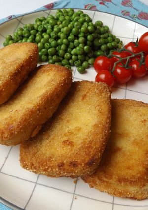 Una foto de Halloumi rebozado y frito con guisantes y tomatitos en rama baby