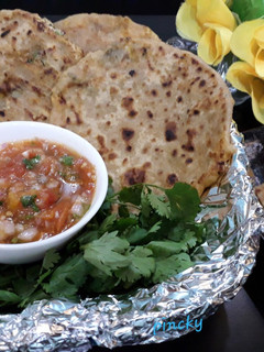 A picture of Stuffed paneer paratha with tomato onion chutney.