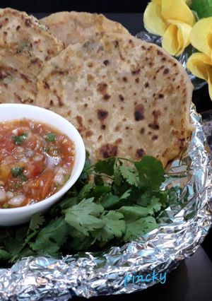A picture of Stuffed paneer paratha with tomato onion chutney.