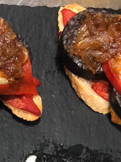 Una foto de Tosta de morcilla de Burgos con rulo de Cabra y cebolla caramelizada