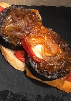 Una foto de Tosta de morcilla de Burgos con rulo de Cabra y cebolla caramelizada