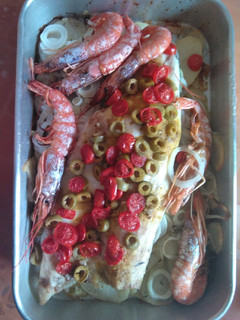 Una foto de Lubina al horno con gambón, aceituna y cherry