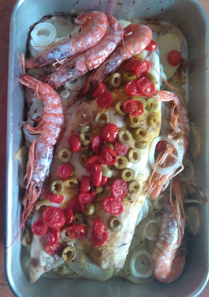 Una foto de Lubina al horno con gambón, aceituna y cherry