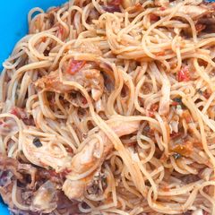 A picture of Spaghetti jollof with shredded chicken.