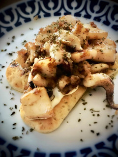 Una foto de Sepia encebollada sobre mini focaccias a la pimienta
