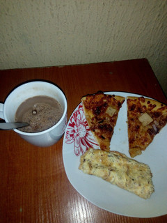 A picture of Fried eggs,left over Pizza and Hot Choco.