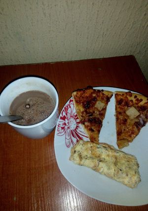A picture of Fried eggs,left over Pizza and Hot Choco.