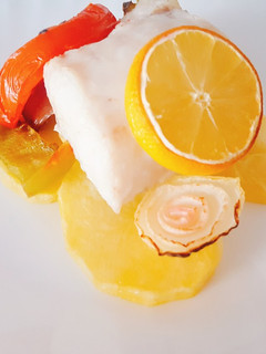 Una foto de Merluza con limón en cama de verduras al horno