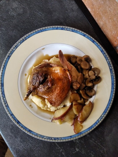 Una foto de Confit de pato con manzana y champiñones