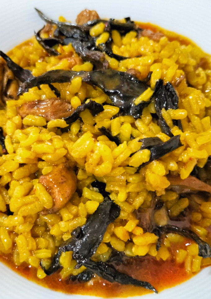 Una foto de Arroz meloso con pollo y trompetas de la muerte