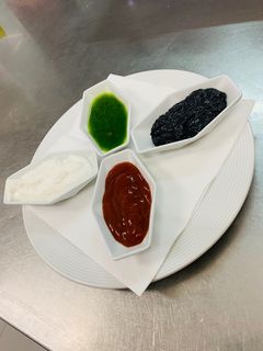 Una foto de 4 salsas para tapas: Salsa brava, ajo-aceite, alioli negro y salsa verde