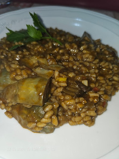 Una foto de Arroz meloso de alcachofas y conserva de pota en su tinta