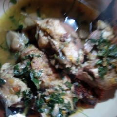 A picture of Cat fish pepper soup garnished with scent leaves and yellow pep.
