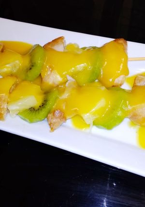 Una foto de Brochetas de pollo, piña y kiwi, con salsa de naranja