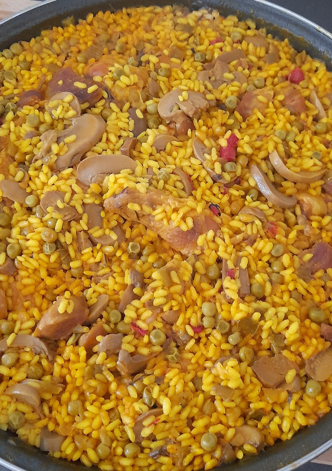 Una foto de Paella de pollo y magro con champiñones