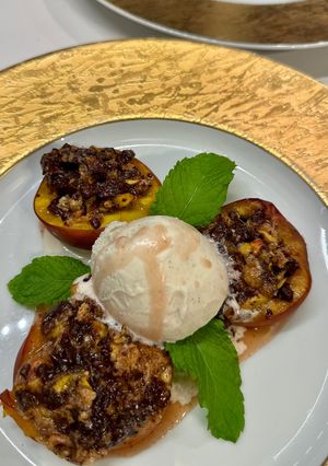 A picture of Baked Peaches with Amaretti, Dark Chocolate, Ice Cream and Mint.