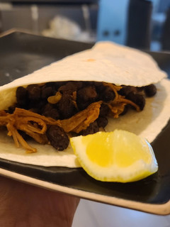 Una foto de Tacos de carne mechada y porotos negros