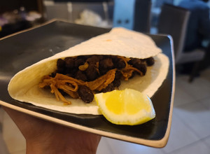 Una foto de Tacos de carne mechada y porotos negros