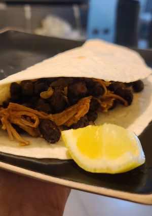 Una foto de Tacos de carne mechada y porotos negros
