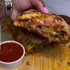A picture of HEAVY meat lovers Stromboli.