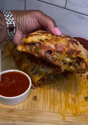 A picture of HEAVY meat lovers Stromboli.