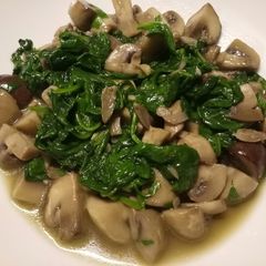 A picture of Sauteed mushrooms and wilted spinach in garlic butter.