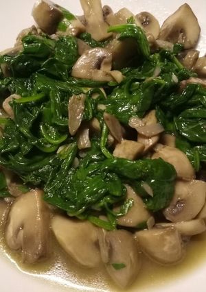 A picture of Sauteed mushrooms and wilted spinach in garlic butter.