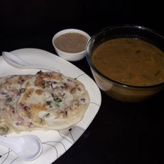 A picture of Onion Uthappam with sambar or chana dal peanut chutney.