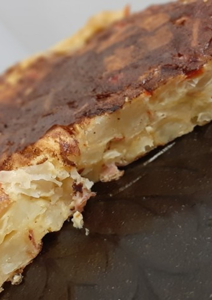 Una foto de Tortilla de papas, cebolla, morrón y panceta ahumada