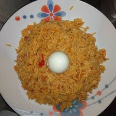 A picture of Jollof rice with boiled egg.