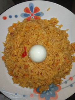 A picture of Jollof rice with boiled egg.